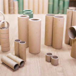 Tubos de papel de diferentes diâmetros e comprimentos sobre uma mesa.